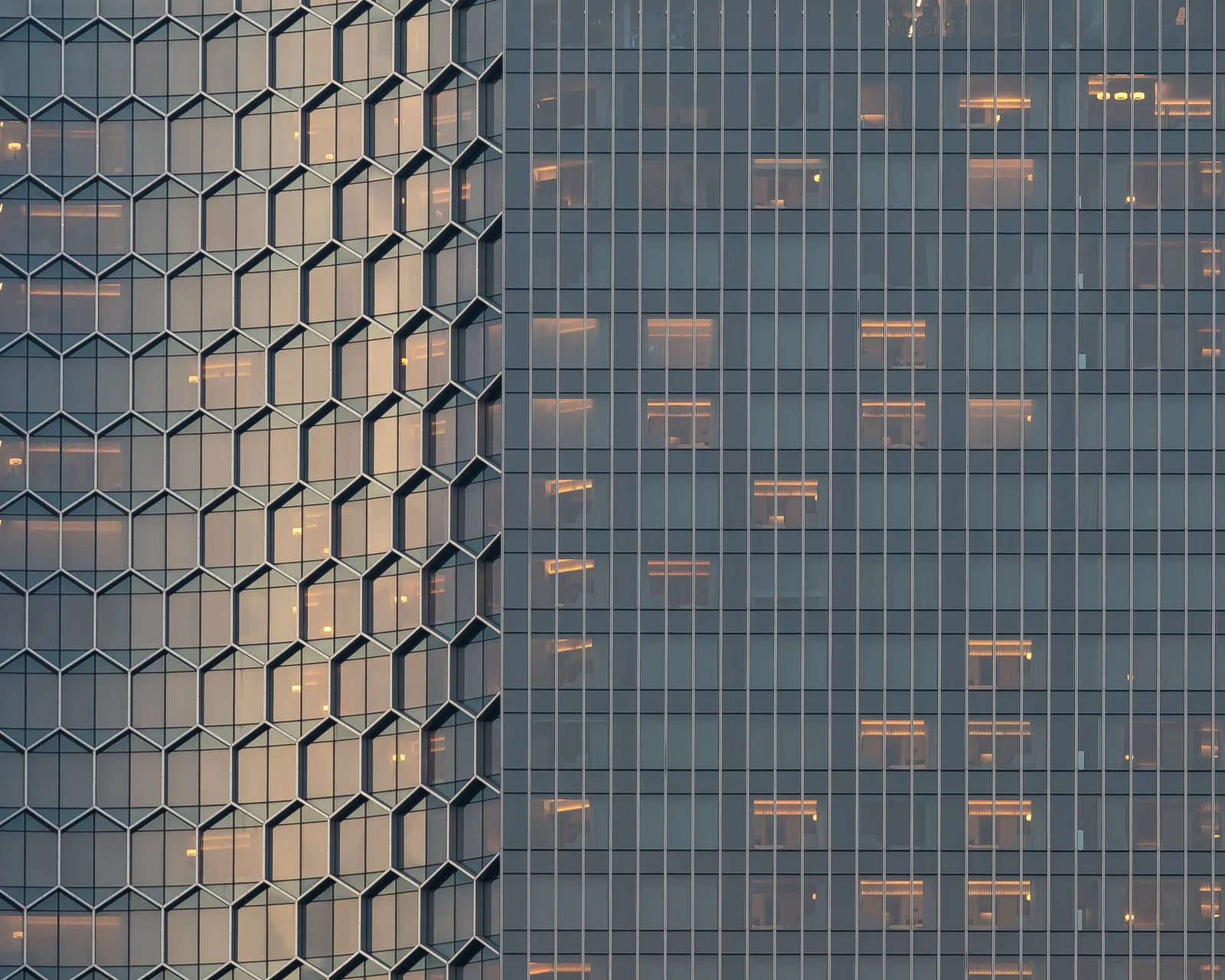 Detail of a glass office tower facade at dusk